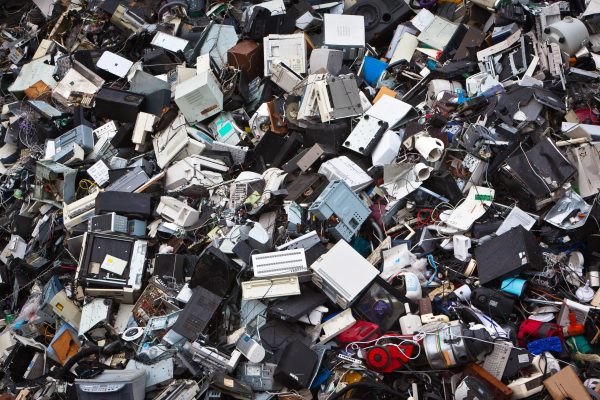 Large pile of discarded electronic devices and computer equipment representing electronic waste generated at the end of product life cycles