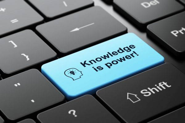 Close-up of a keyboard with a blue key reading “Knowledge is power”