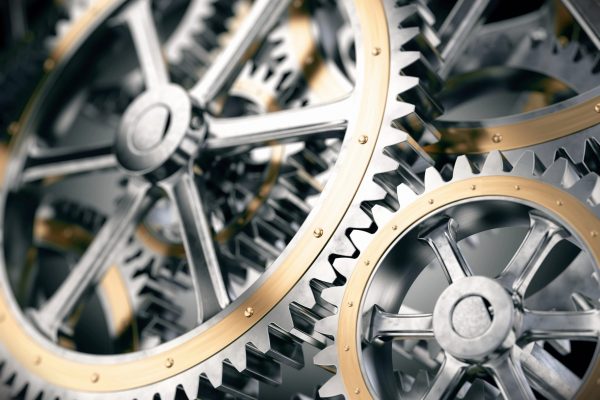 Interlocking mechanical gears symbolizing consistent international IT asset disposition standards with unified processes, rules, and documentation across countries.