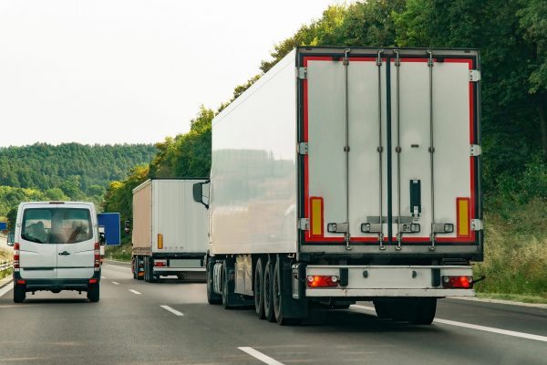 Cargo trucks transporting goods on a highway representing logistics and controlled transport processes